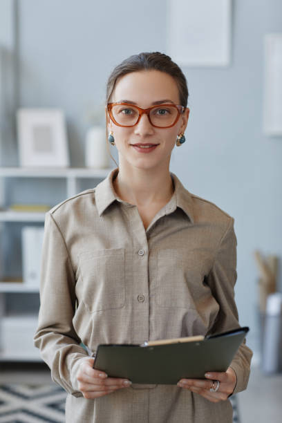 istock Businesswoman looking at camera while standing by workplace 1499253584