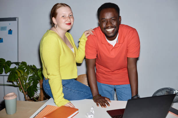 istock Smiling two people looking at camera at workplace and leaning on desk 1499256728