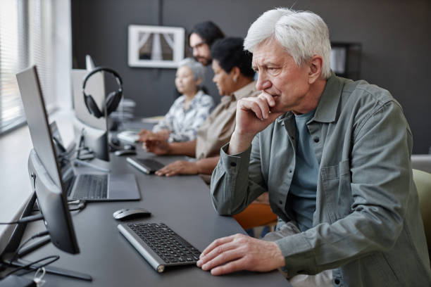 istock Confused senior man using computer in tech school for elderly people 1499258424
