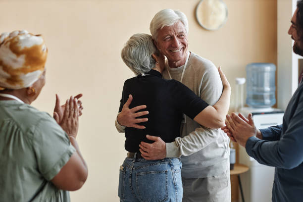 istock Senior people applauding and embracing in support group 1499258478