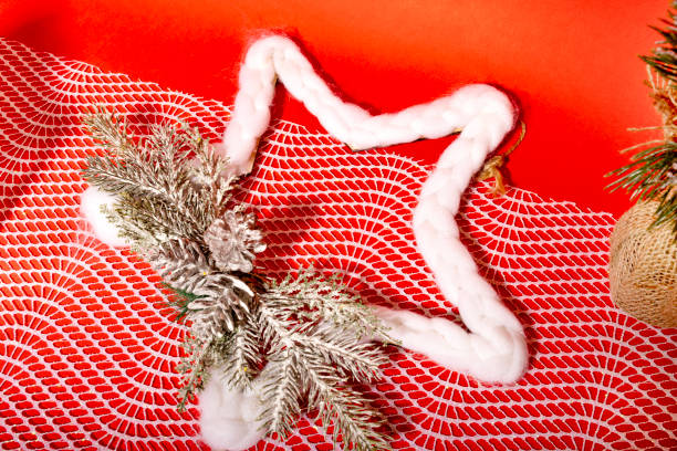 Christmas decor white cotton star against red background.
