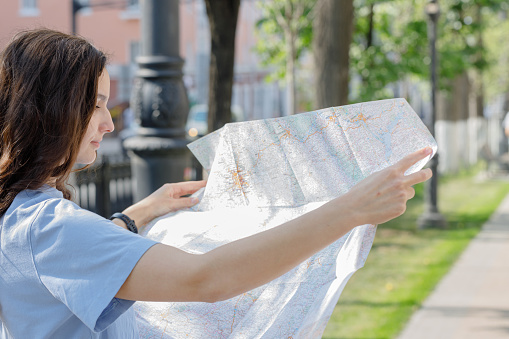 girl holding map, tourist searching way, travelling, standing over white background