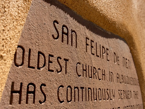 Albuquerque, New Mexico - USA, May 10, 2023. Historical marker cut into the adobe of San Felipe de Neri Catholic Church.