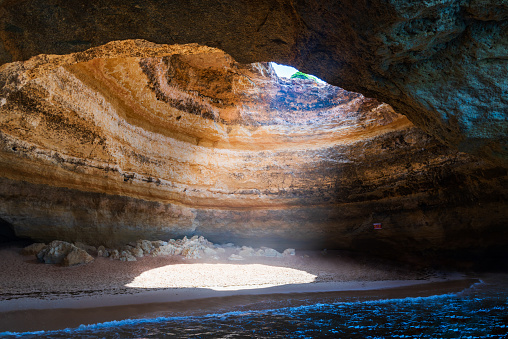 Benagil cave,with a small beach and a hole in its upper part,in the cliffs of the Algarve.