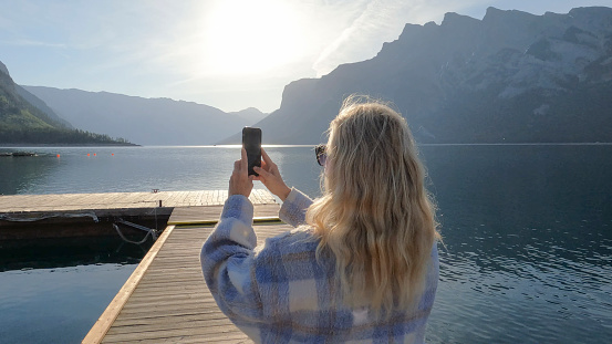 She takes smart phone pic of view. Lake Minnewanka, Banff NP, Alberta