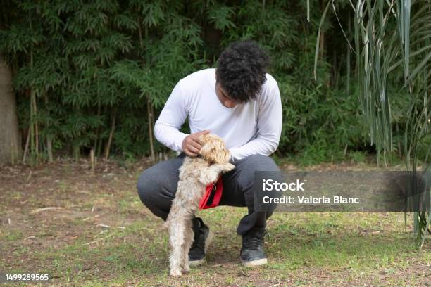 Young Man With Pet Playing Outdoors Stock Photo - Download Image Now - 20-24 Years, Adult, Adults Only