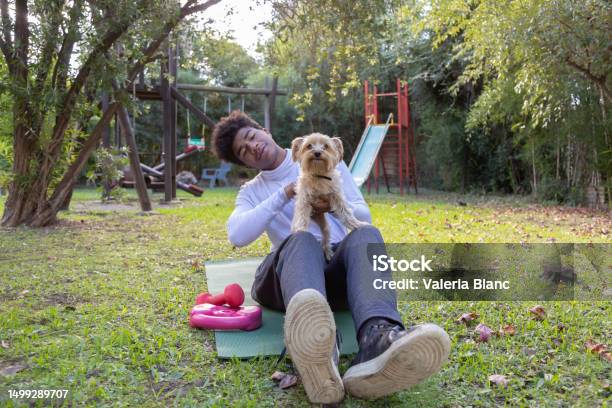 Young Man With Pet Playing On The Ground Outdoors Stock Photo - Download Image Now - 20-24 Years, Adult, Adults Only