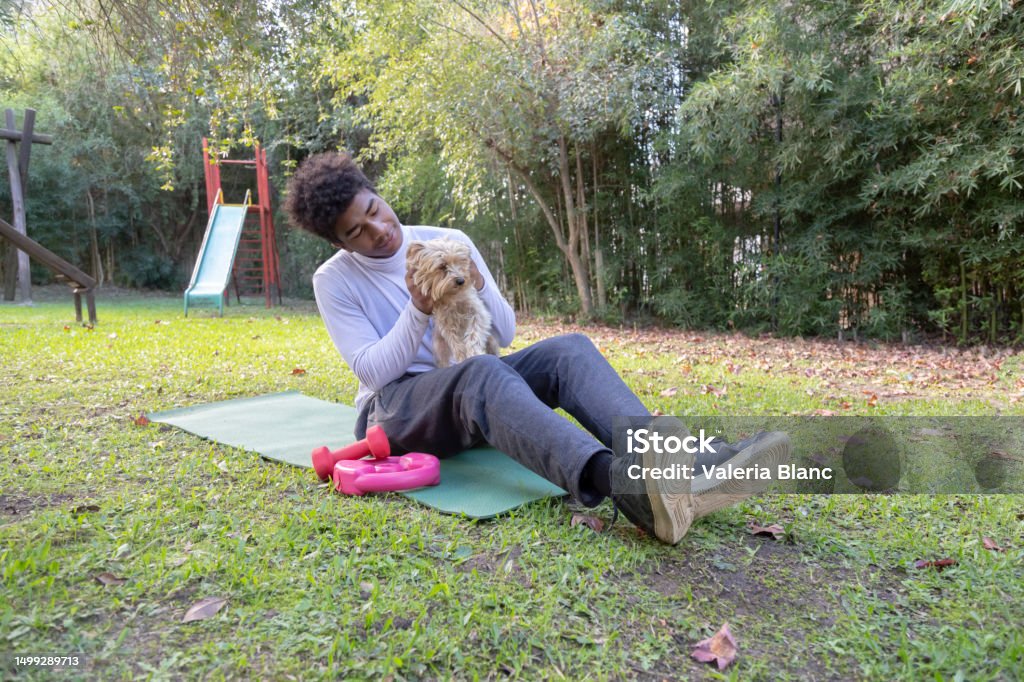 young man with pet playing on the ground outdoors young man with Yorkshire 20-24 Years Stock Photo