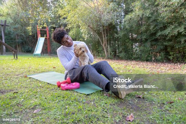 Young Man With Pet Playing On The Ground Outdoors Stock Photo - Download Image Now - 20-24 Years, Adult, Adults Only