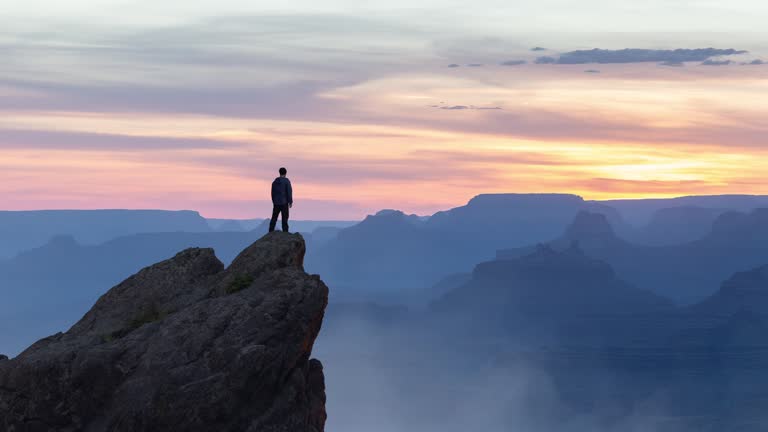 Epic Adventure Composite of Man Hiker on top of a rocky mountain.