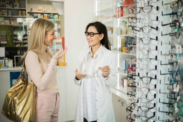 istock Asian pharmacist showing some eyeglasses to a young customer 1499309420
