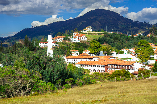 Colombia, South America - A section of the Andes town of Guatavita in the Cundinamarca department of the South American country of Colombia. The altitude is about 8660 feet above mean sea level. In the background are the Andes mountains. The bell tower of the church on the main square can be seen to the left of the photo. Photo shot in the afternoon sunlight;  horizontal format. Copy space.