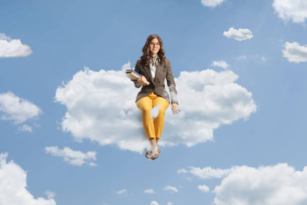 istock Female teacher holding books and sitting on a cloud 1499318190