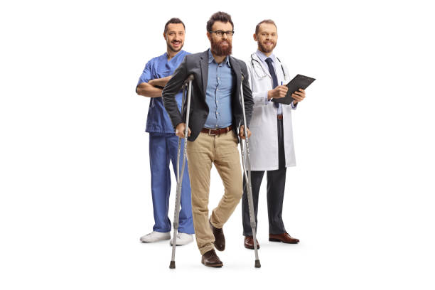 medical team with a male patient standing with crutches - physical injury men orthopedic equipment isolated on white imagens e fotografias de stock