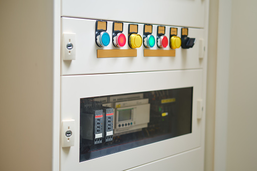 The industrial equipment requires professional maintenance to prevent electrical hazards. In case of an emergency, press the red button on the electrical signal board.