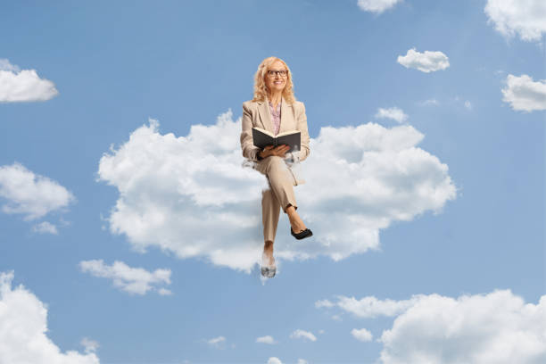 istock Mature woman sitting on a blank panel and reading a book 1499321681