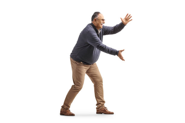 Full length profile shot of a corpulent mature man trying to catch something stock photo