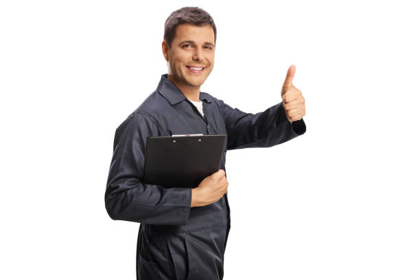 istock Car mechanic gesturing thumbs up and holding a clipboard 1499321733