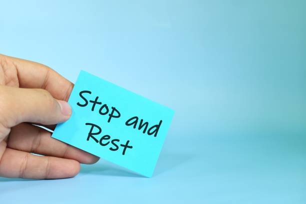 istock Stop and rest reminder concept. Hand holding a bright green paper message note. 1499337855