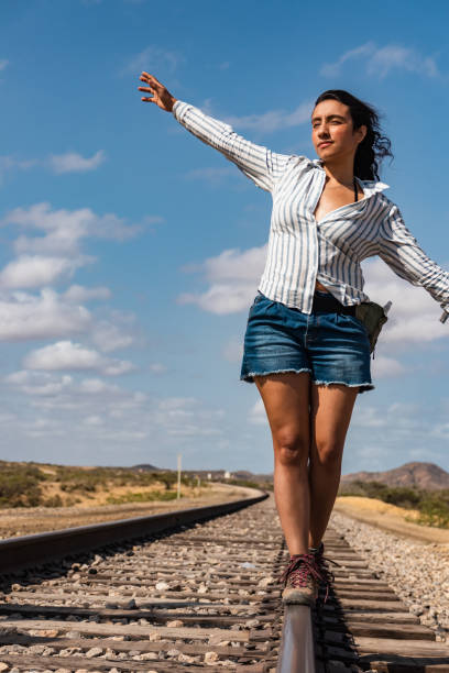istock Connecting with the Infinite: Woman Balancing on Desert Train Tracks 1499338556