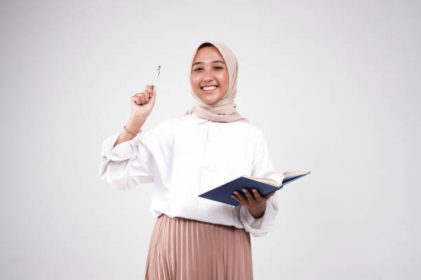 istock Muslimah holding book and a pen 1499344775
