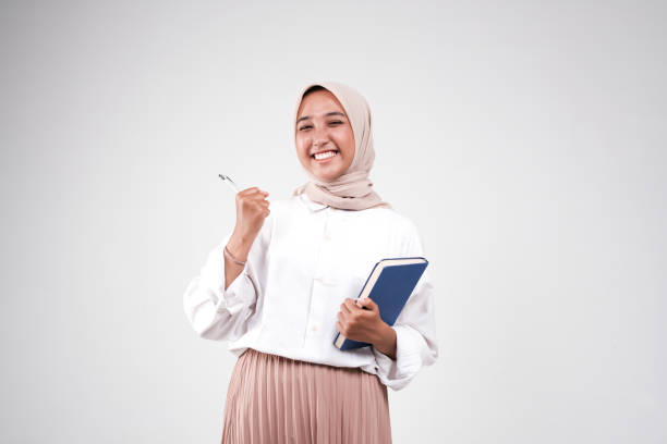 istock Muslimah holding book and a pen 1499344797