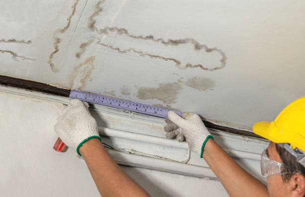 istock Worker fix leaking pipe in ceiling ,close-up of a stain on the ceiling. 1499353990