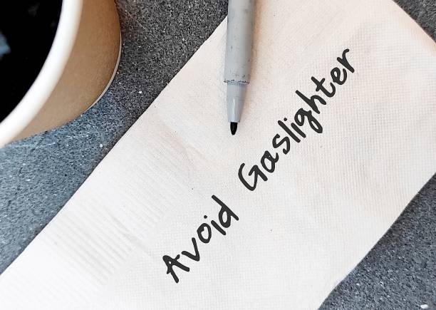 istock Coffee cup and paper napkin with handwritten text AVOID GASLIGHTER, self-reminder to aware abuser who tries to control victim by twisting their sense of reality - manipulation in abusive relationships 1499354394