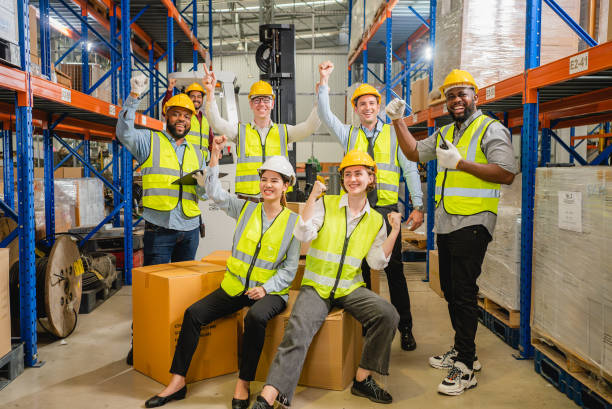 istock Group of happy warehouse workers celebrating success in warehouse 1499376763