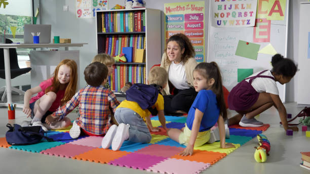 istock Primary school teacher greeting kids running into classroom 1499379138