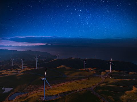 Night view of power wind turbines in the countryside.