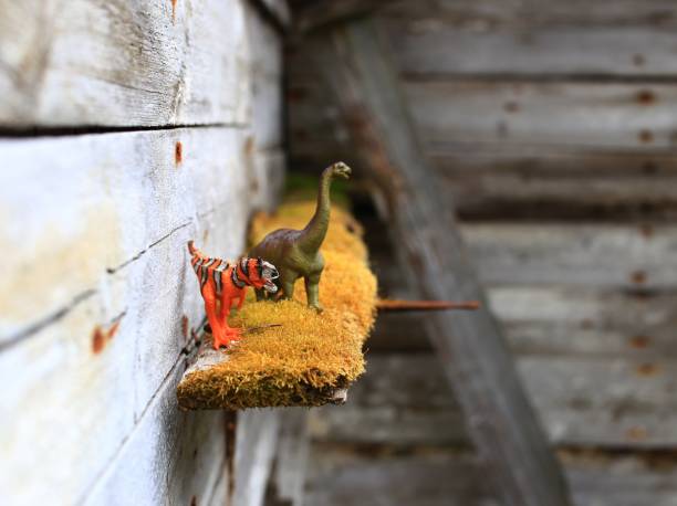 istock Two toy dinosaurs on mossy shelf at ruined wall 1499385035