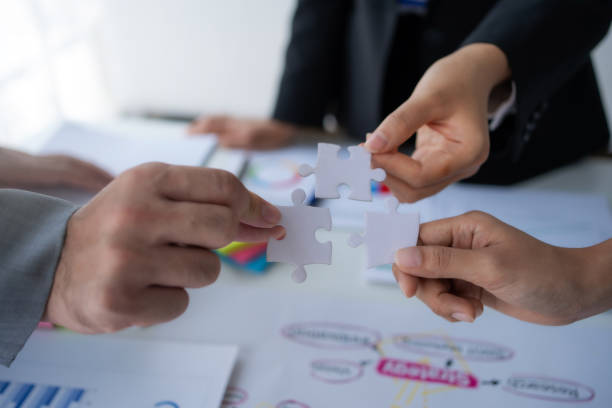 istock Group of business people holding jigsaw puzzles, team solving puzzles, planning together. Unity, teamwork and partnership concept. 1499388741