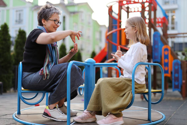 jouant avec un enfant sourd, une femme communique avec une fille en langue des signes. - faders photos et images de collection