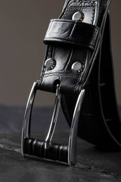 istock Black leather belt with a metal plaque close-up on a gray background. 1499390439