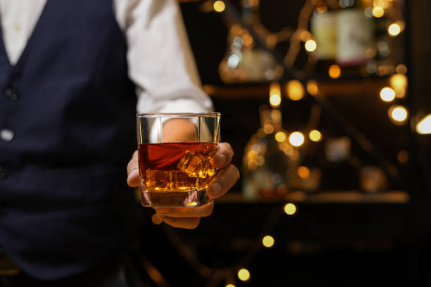 バーにウイスキーを注ぐバーテンダー、 - whisky glass ice cube alcohol ストックフォトと画像