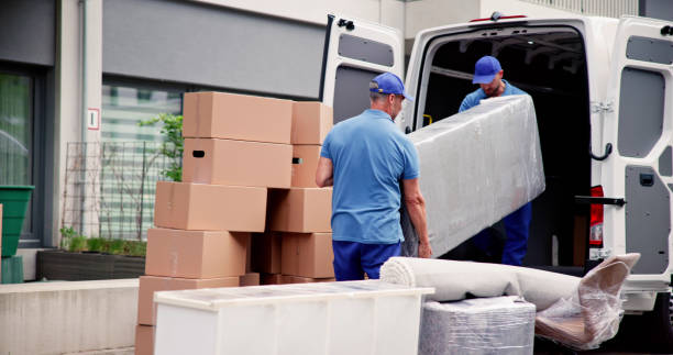 Male Workers In Blue Uniform Unloading Furniture stock photo