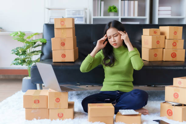 istock Young Asian woman working at small business ecommerce using laptop stressed and frustrated surprised and angry face. Small online business owner Asian woman stressed headache with parcel box at home. 1499394805