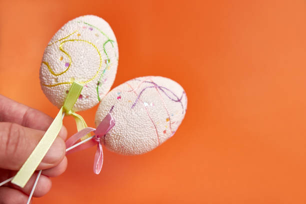 istock They are holding Easter eggs on an orange background. Place for text. 1499394897