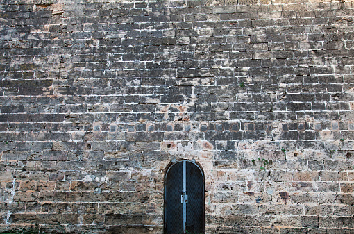 Iron door in an old, antique wall.