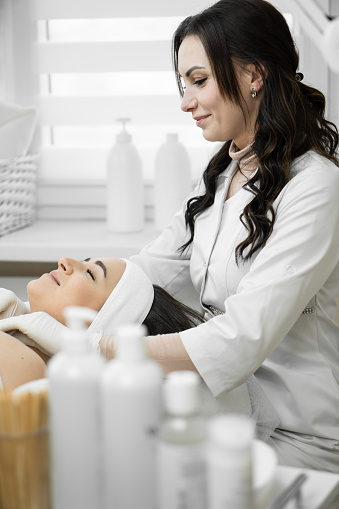 The magic of beauty shows how a cosmetologist in a beauty clinic performs a facial cleansing procedure, giving a woman an unsurpassed look and well-being. Rest and relaxation during the procedure. High quality photo