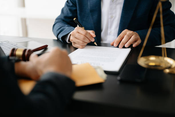 dos abogados están discutiendo sobre el papel del contrato, la determinación de asuntos legales, apuntar a la ley y martillo sobre la mesa - abogado fotografías e imágenes de stock