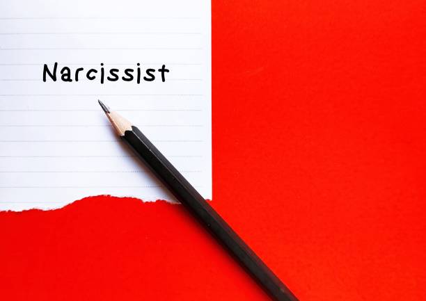 istock Torn paper on red copy space backgroundl with handwritten text NARCISSIST, self-centered inflated people of importance, need attention and admiration but lack empathy to others 1499402919