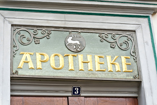 Lettering Apotheke above the entrance door of a historic pharmacy in the old town of Goslar in Germany