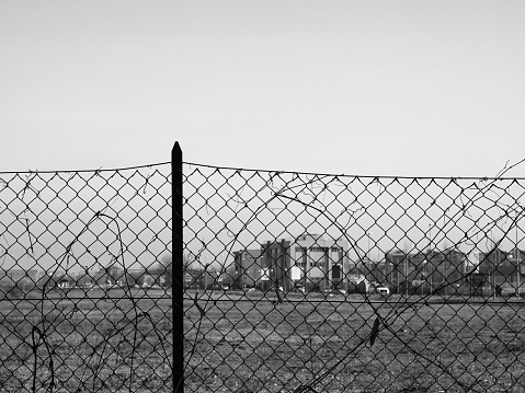 wire mesh fence with blurred out of focus building in the background