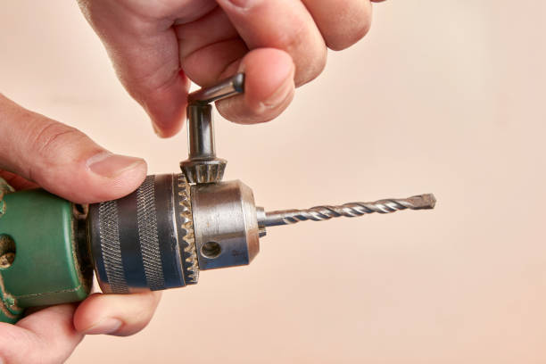 istock A drill is added to the electric drill. Preparing the drill for work. 1499409244