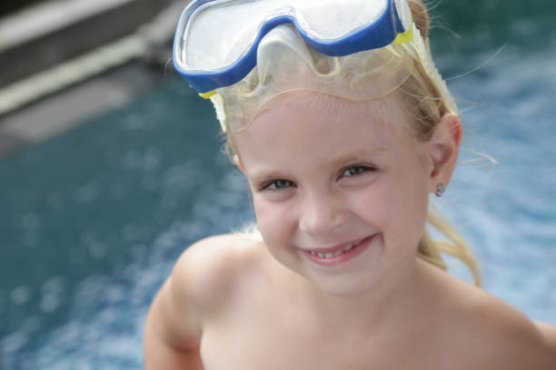 adorable niña alegre de 5 años con máscara de snorkel posando junto a la piscina - eyewear child glasses 6 7 years fotografías e imágenes de stock