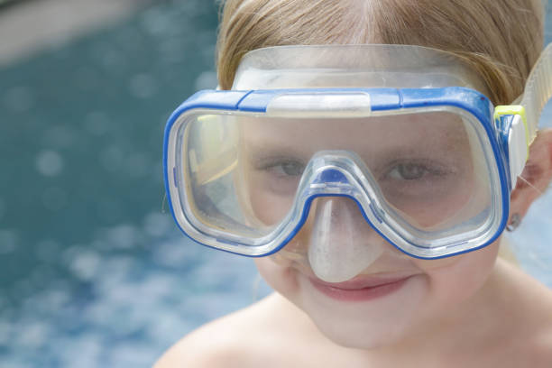 adorable niña alegre de 5 años con máscara de snorkel posando junto a la piscina - eyewear child glasses 6 7 years fotografías e imágenes de stock