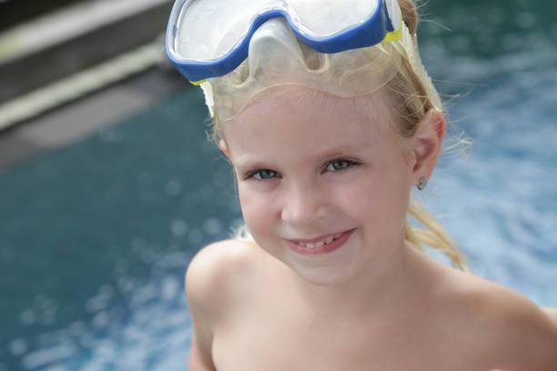 adorable niña alegre de 5 años con máscara de snorkel posando junto a la piscina - eyewear child glasses 6 7 years fotografías e imágenes de stock