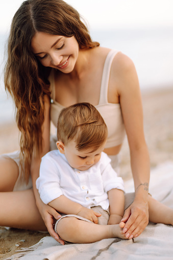 Mother with a child have fun on the beach. Family, childhood, active lifestyle concept.
